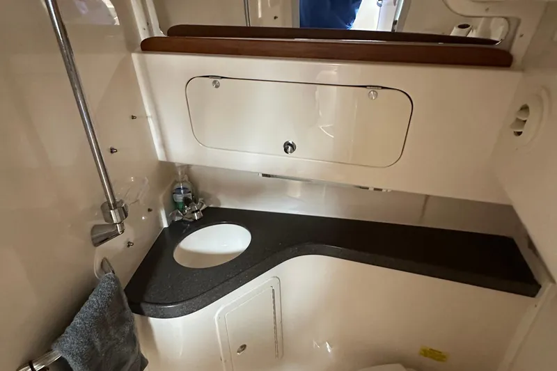 Slide: The Image of 2008 Grady-White Express 330 boat bathroom with sink and storage cabinet. - 49