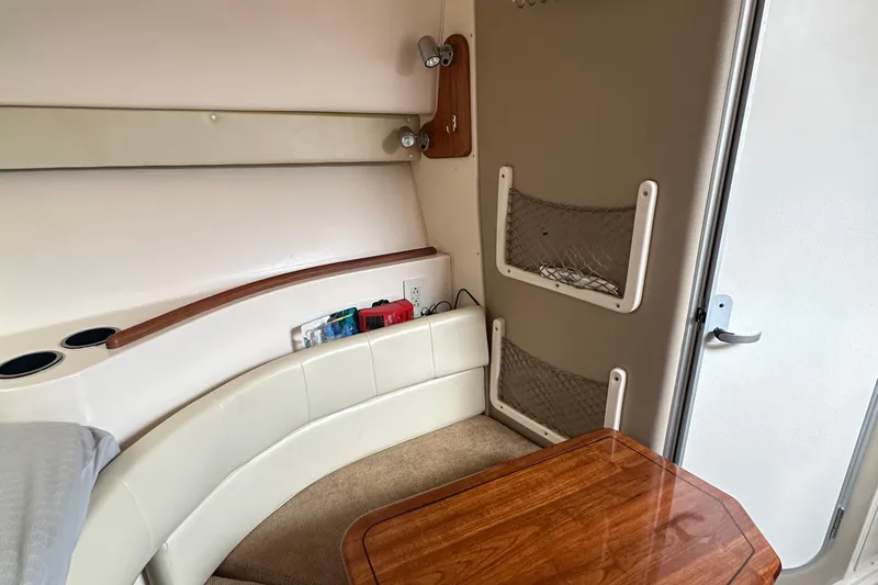 Slide: The Image of 2008 Grady-White Express 330 cabin interior with seating, table, and storage nets. - 50