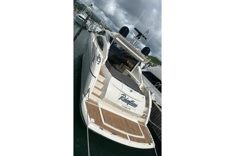 Slide: The Image of 2009 Sunseeker Predator 62 yacht docked, showcasing sleek design and spacious deck. - 17