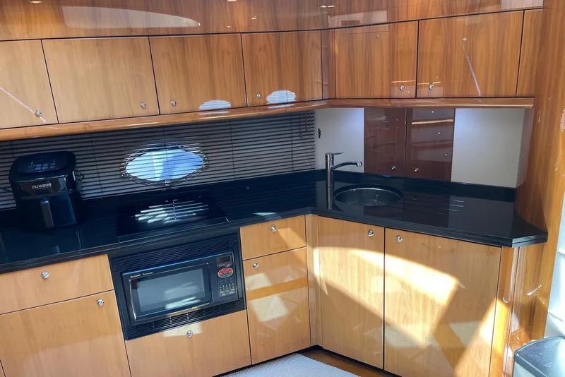 Slide: The Image of Luxurious 2009 Sunseeker Predator 62 yacht kitchen with sleek wood cabinetry and modern appliances. - 23