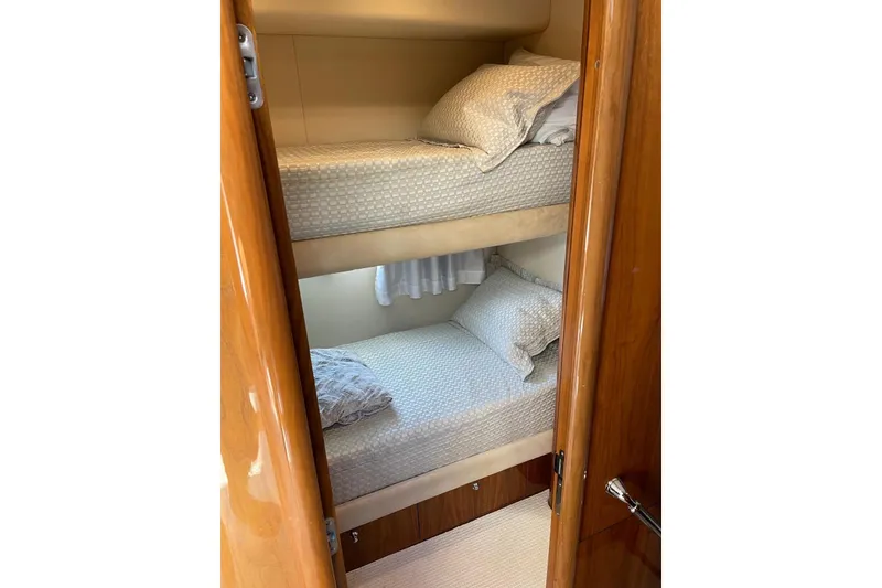 Slide: The Image of Bunk beds in 2009 Sunseeker Predator 62 yacht cabin, featuring wooden finishes and cozy bedding. - 31