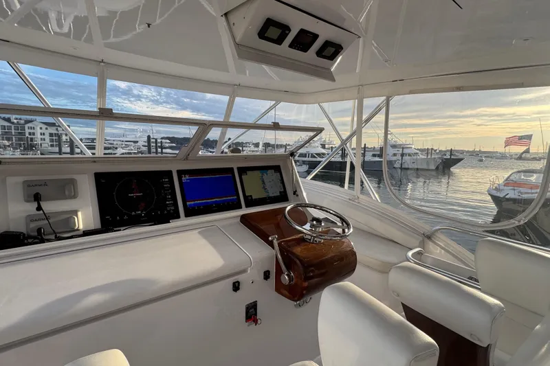 Slide: The Image of Helm of 2013 Hatteras GT54 yacht with navigation screens, overlooking marina at sunset. - 3