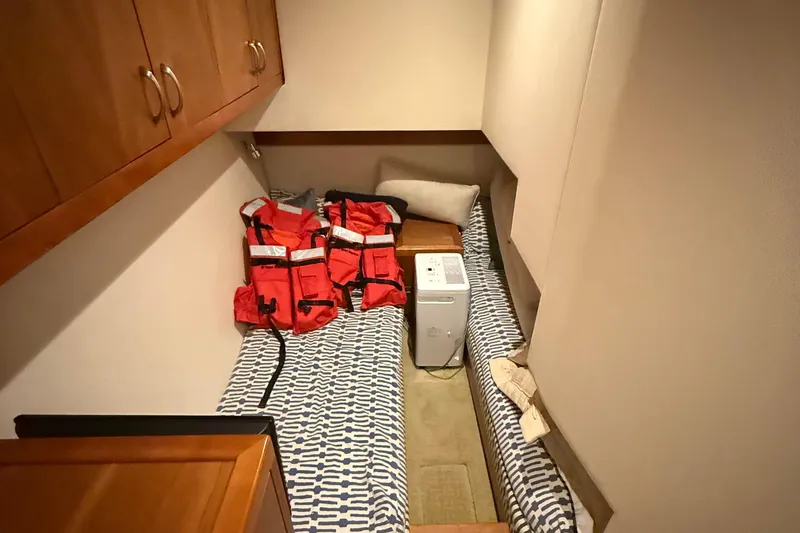 Slide: The Image of 2013 Hatteras GT54 cabin with life jackets and patterned bedding. - 19