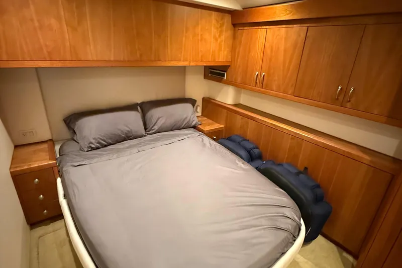 Slide: The Image of Luxurious 2013 Hatteras GT54 yacht bedroom with wooden cabinetry and cozy bedding. - 12