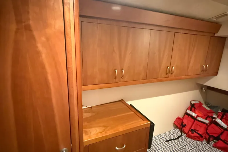 Slide: The Image of Wooden cabinetry and storage in 2013 Hatteras GT54 interior, with red life jackets visible. - 17