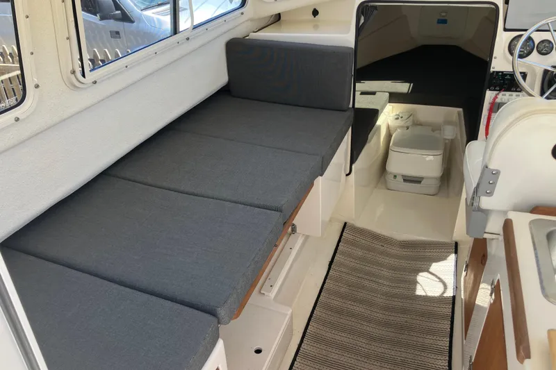 Slide: The Image of Interior of 2014 C-Dory 22 Cruiser with seating, toilet, and steering wheel. - 10