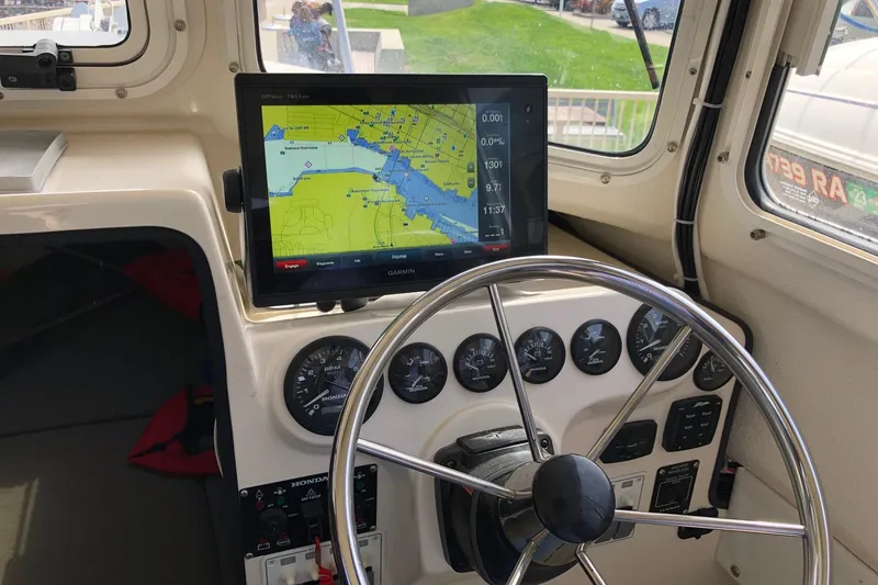 Slide: The Image of Steering wheel and navigation system inside a 2014 C-Dory 22 Cruiser boat. - 12