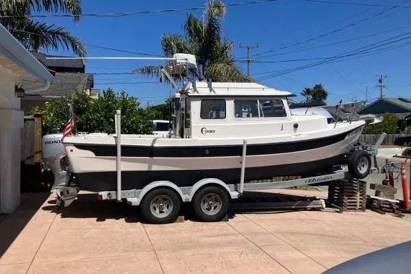 Slide: The Image of 2014 C-Dory 22 Cruiser on trailer, parked in driveway, sunny day. - 2