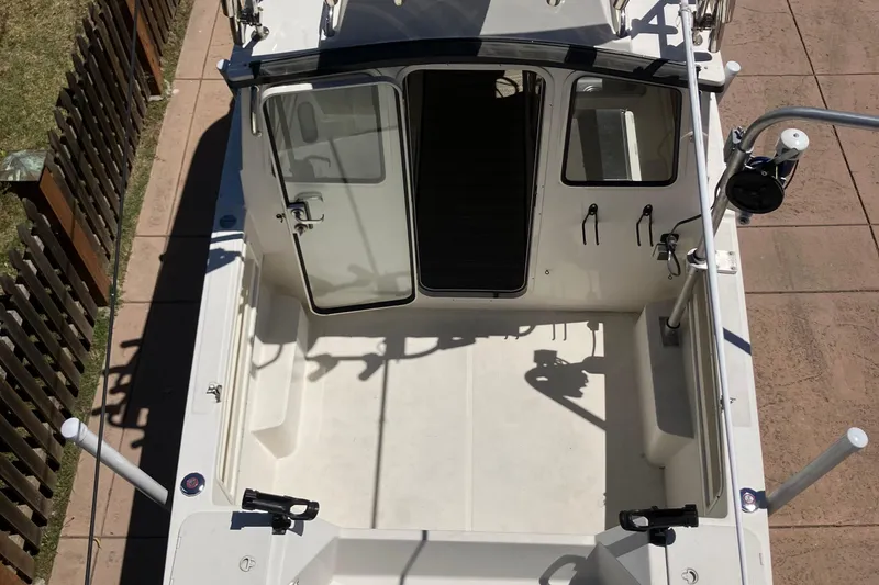 Slide: The Image of 2014 C-Dory 22 Cruiser boat interior, open cockpit view with seating and fishing rod holders. - 3