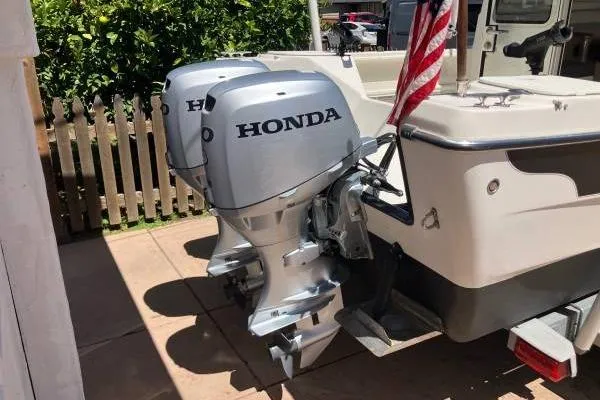 Slide: The Image of 2014 C-Dory 22 Cruiser with dual Honda outboard motors and American flag. - 4