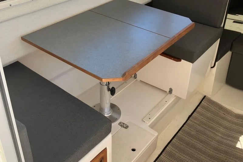 Slide: The Image of 2014 C-Dory 22 Cruiser interior with table and cushioned seating. - 7