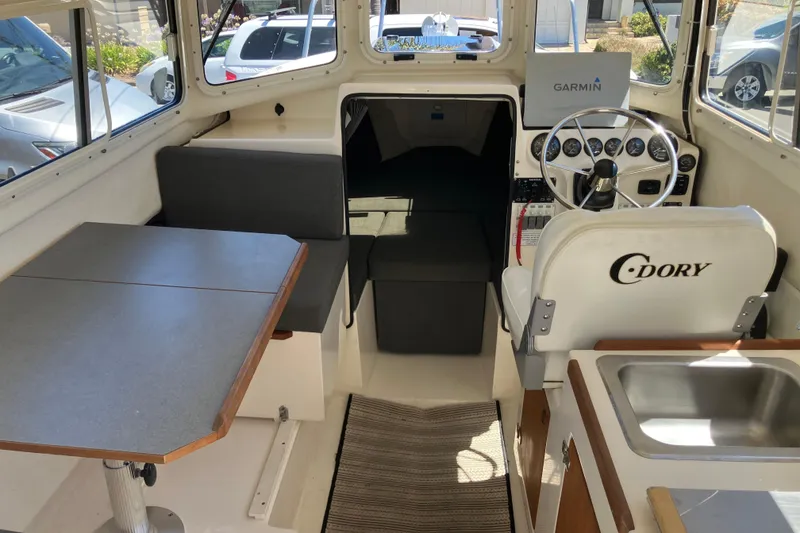 Slide: The Image of Interior of 2014 C-Dory 22 Cruiser with table, seating, and steering console. - 8