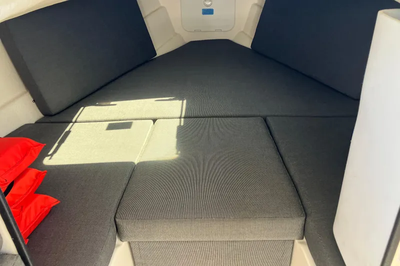 Slide: The Image of Interior cabin of 2014 C-Dory 22 Cruiser with gray cushions and red life jackets. - 9