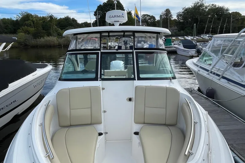 Slide: The Image of 2020 Pursuit DC 235 Dual Console boat docked, featuring spacious seating and Garmin equipment. - 11