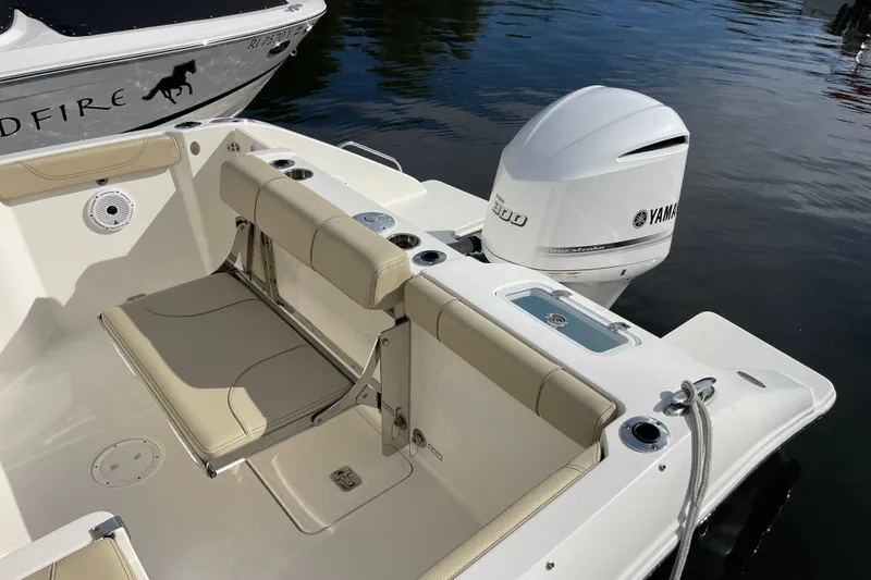 Slide: The Image of 2020 Pursuit DC 235 Dual Console boat with Yamaha outboard engine, docked on calm water. - 2