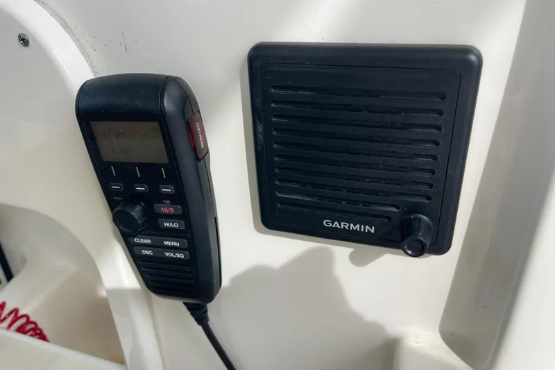 Slide: The Image of VHF radio and Garmin speaker on 2020 Pursuit DC 235 Dual Console boat. - 21