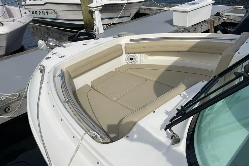 Slide: The Image of 2020 Pursuit DC 235 Dual Console boat with beige seating at a marina dock. - 28