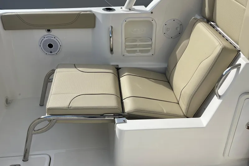 Slide: The Image of 2020 Pursuit DC 235 Dual Console boat seat with beige upholstery and stainless steel frame. - 29