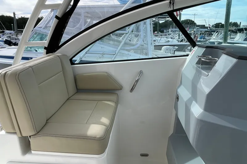 Slide: The Image of 2020 Pursuit DC 235 Dual Console boat interior with beige seating and cup holders. - 31
