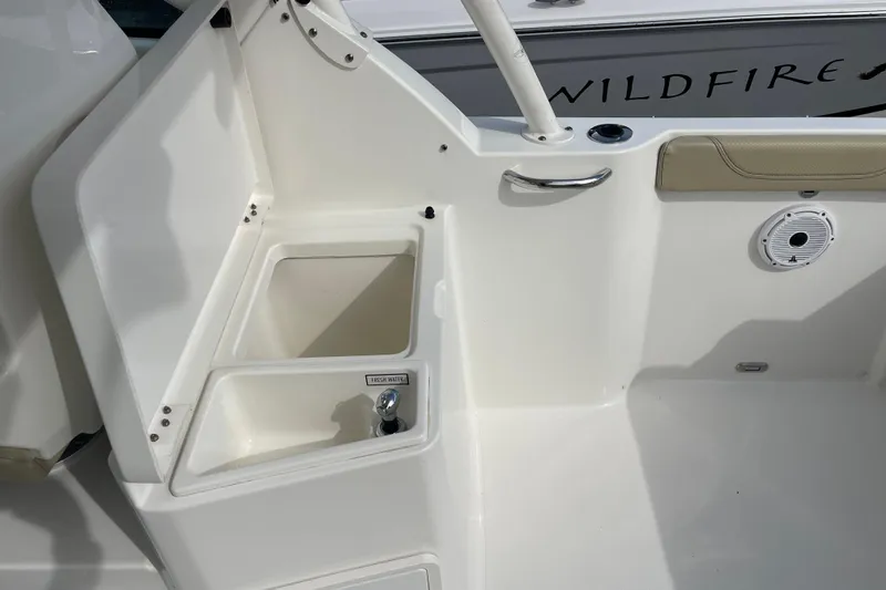 Slide: The Image of 2020 Pursuit DC 235 Dual Console boat interior with storage compartment and freshwater access. - 35