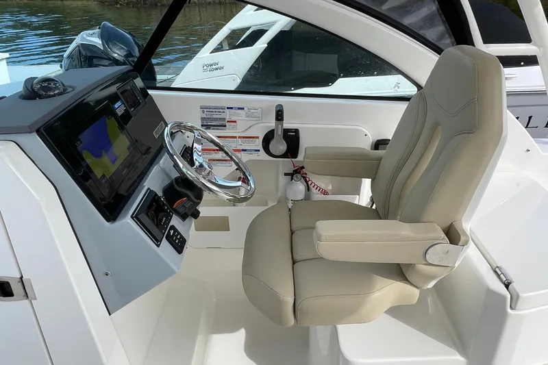 Slide: The Image of 2020 Pursuit DC 235 Dual Console boat interior with steering wheel and navigation display. - 37