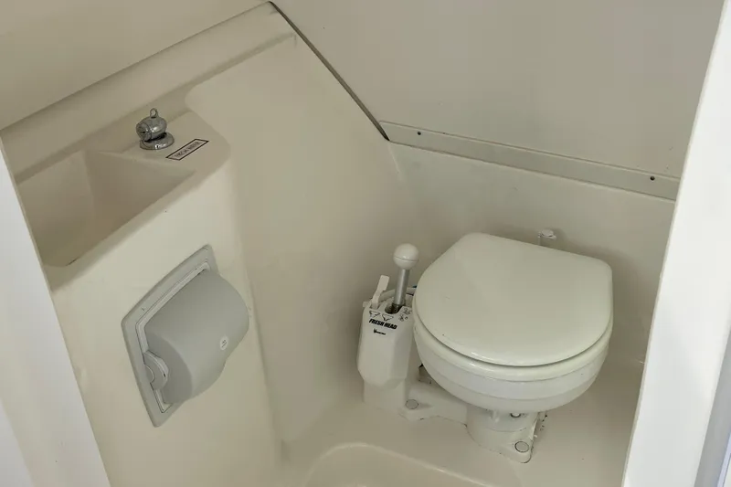 Slide: The Image of 2020 Pursuit DC 235 Dual Console boat bathroom with compact toilet and sink. - 41