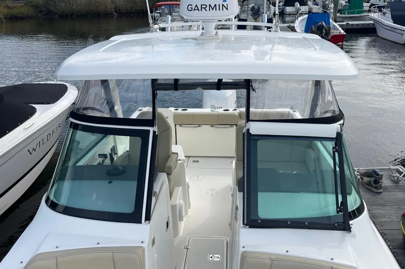 Slide: The Image of 2020 Pursuit DC 235 Dual Console boat docked, featuring Garmin equipment. - 49
