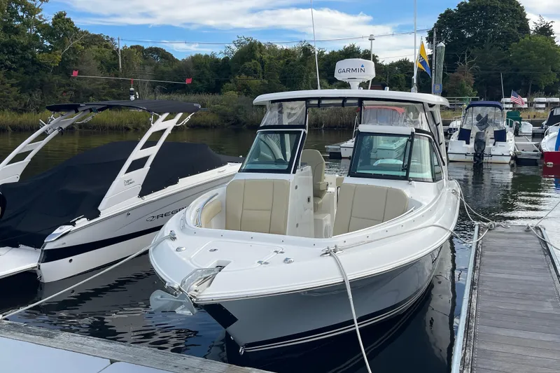Slide: The Image of 2020 Pursuit DC 235 Dual Console boat docked at marina, surrounded by other vessels. - 5
