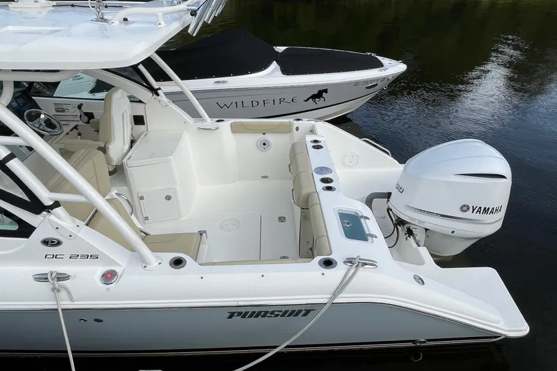 Slide: The Image of 2020 Pursuit DC 235 Dual Console boat with Yamaha engine, docked on calm water. - 50