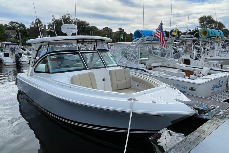 Slide: The Image of 2020 Pursuit DC 235 Dual Console boat docked at marina with American flag. - 51