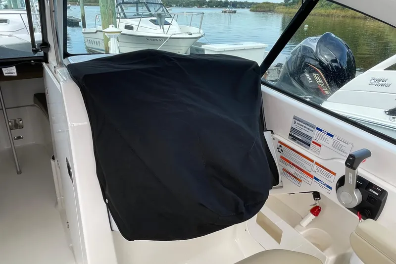 Slide: The Image of 2020 Pursuit DC 235 Dual Console interior with covered dashboard and Yamaha engine controls. - 59