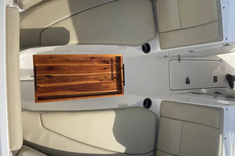 Slide: The Image of 2020 Pursuit DC 235 Dual Console interior with beige seating and wooden table. - 7