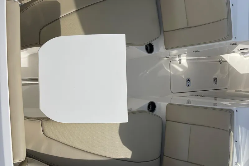 Slide: The Image of 2020 Pursuit DC 235 Dual Console interior with beige seating and white table. - 9