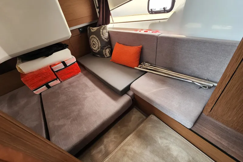 Slide: The Image of Cozy interior seating area of 2022 Beneteau Antares 11 with cushions and storage. - 19