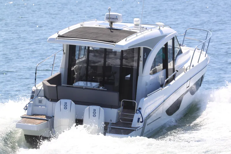 Slide: The Image of 2022 Beneteau Antares 11 cruising on water, rear view with twin engines. - 2