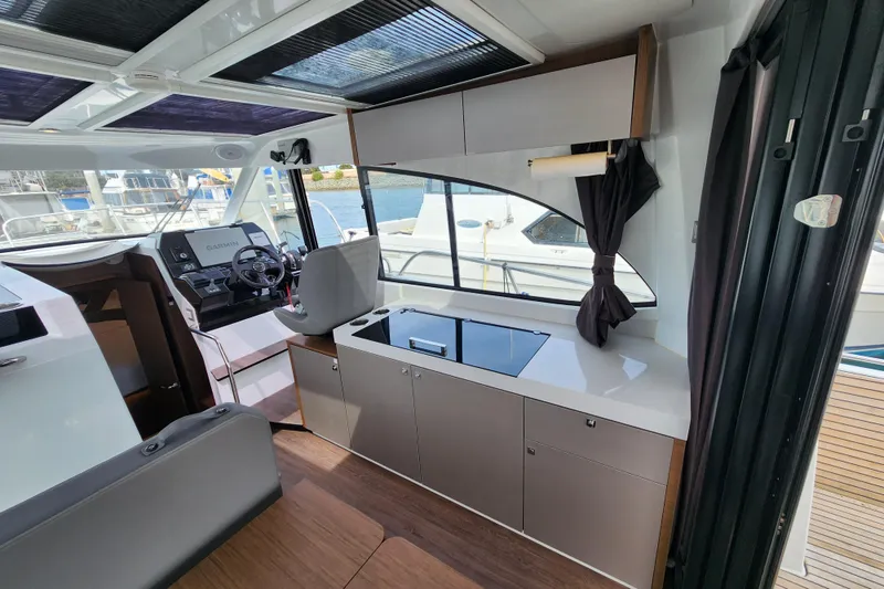 Slide: The Image of Interior of 2022 Beneteau Antares 11, featuring helm station and modern kitchenette. - 23