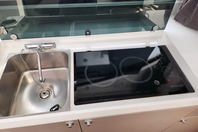 Slide: The Image of Modern kitchen area in 2022 Beneteau Antares 11 with sink and Kenyon cooktop. - 40