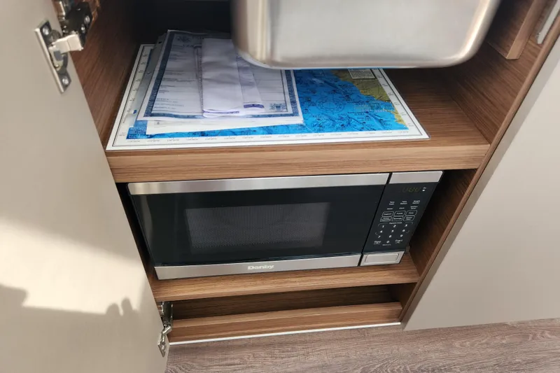 Slide: The Image of Microwave and maps inside Beneteau Antares 11 cabinet, 2022 model. - 41