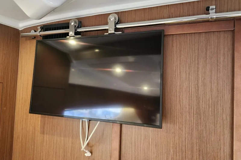 Slide: The Image of Flat-screen TV mounted on wood panel inside 2022 Beneteau Antares 11 boat. - 47