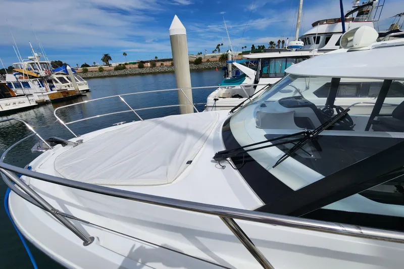 Slide: The Image of 2022 Beneteau Antares 11 docked in a marina under a clear blue sky. - 6
