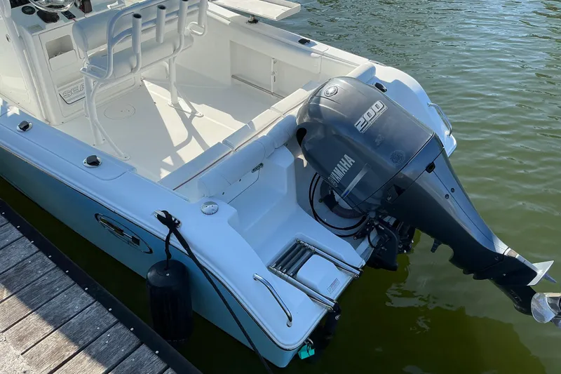Slide: The Image of 2019 Sea Hunt Ultra 225 boat with Yamaha 200 outboard motor docked by the water. - 10