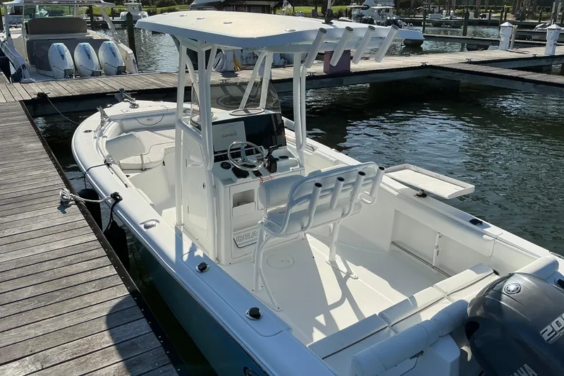 Slide: The Image of 2019 Sea Hunt Ultra 225 boat docked at marina, featuring center console and Yamaha engine. - 11