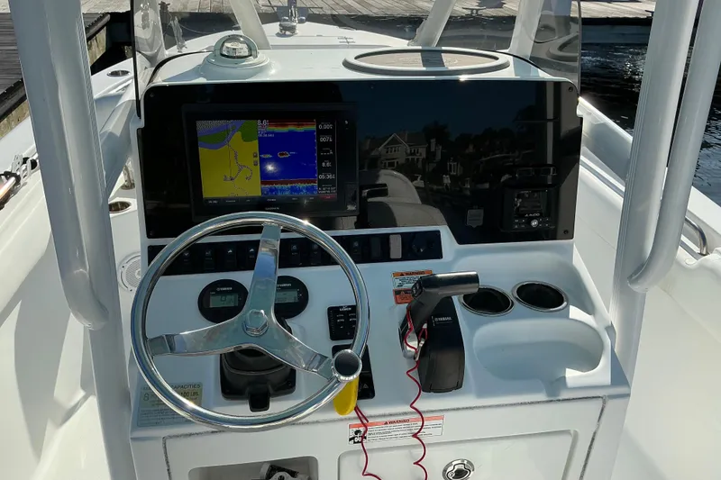 Slide: The Image of 2019 Sea Hunt Ultra 225 boat dashboard with steering wheel and navigation display. - 13