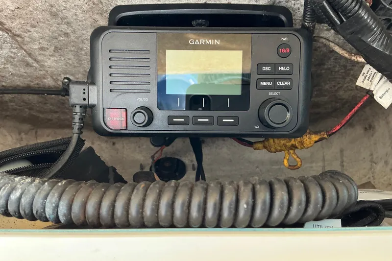 Slide: The Image of Garmin marine radio on 2019 Sea Hunt Ultra 225 boat dashboard, featuring distress button. - 18