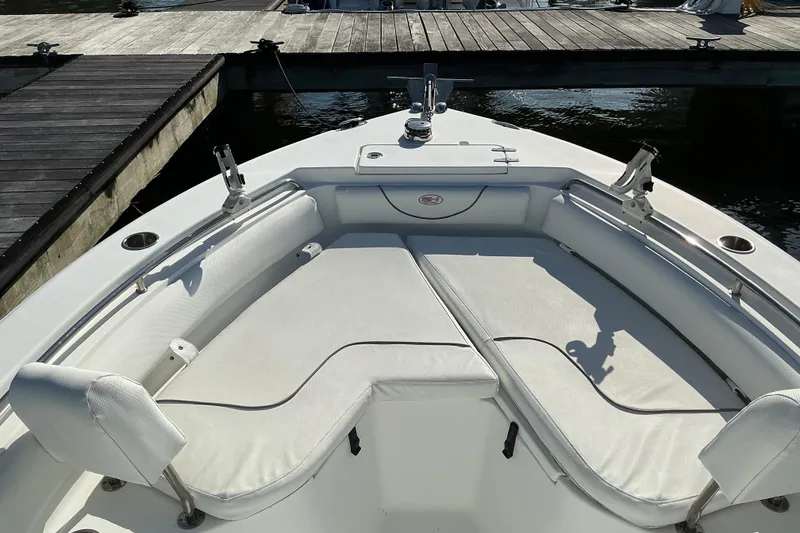 Slide: The Image of 2019 Sea Hunt Ultra 225 boat interior with cushioned seating at dock. - 19
