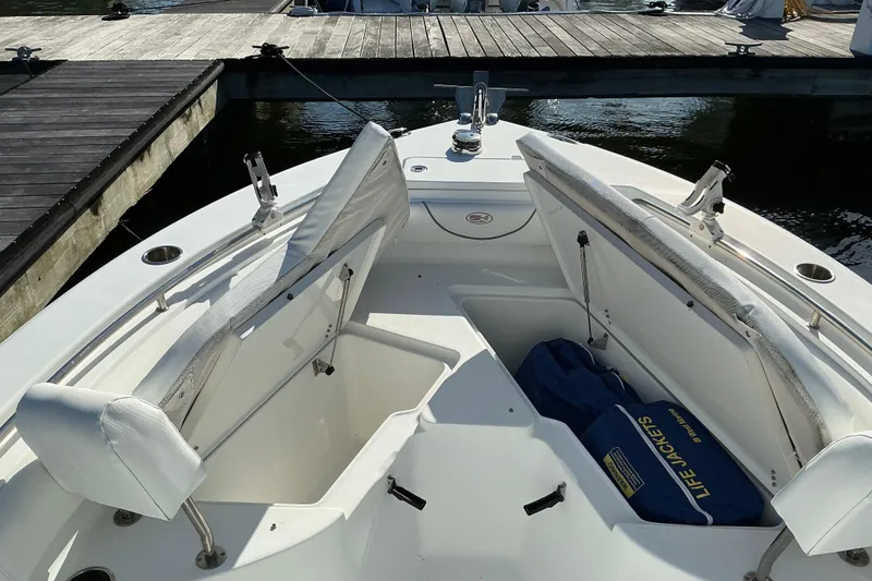 Slide: The Image of 2019 Sea Hunt Ultra 225 boat interior with open storage compartments and life jackets. - 20