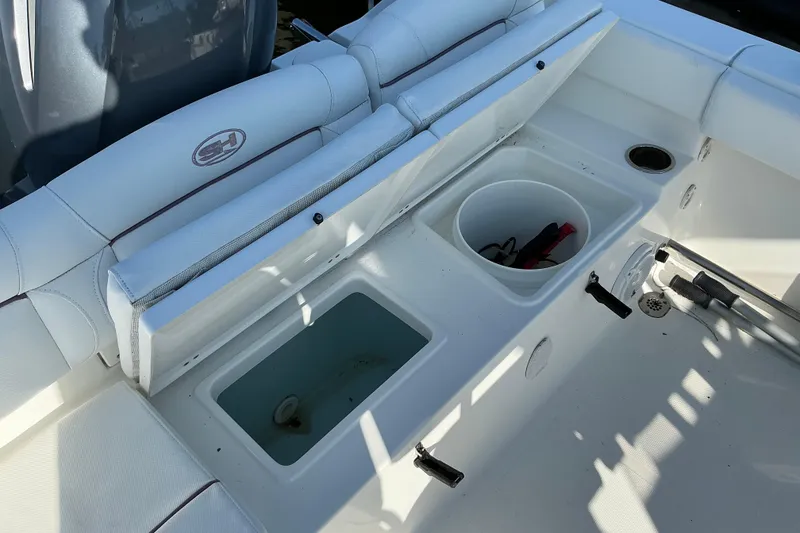 Slide: The Image of 2019 Sea Hunt Ultra 225 boat interior with storage compartments and seating. - 24