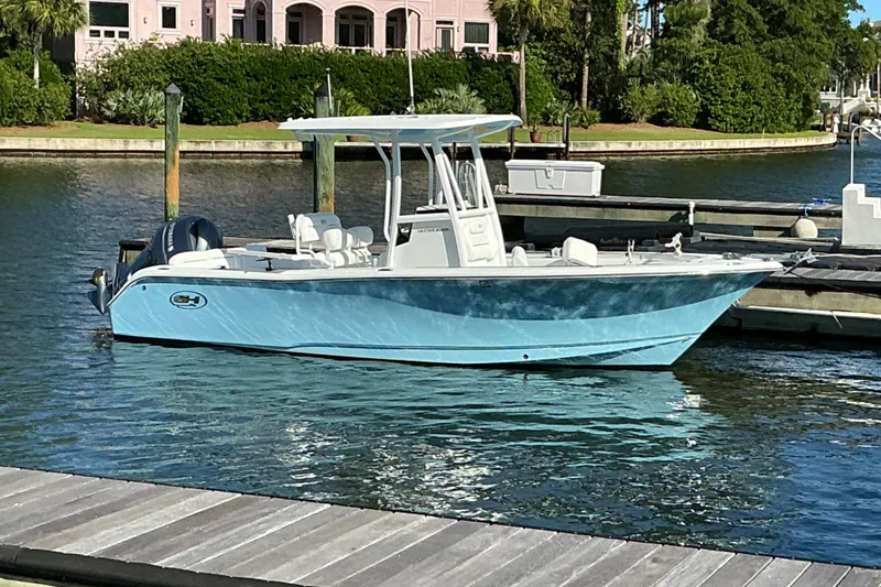 The Image of 2019 Sea Hunt Ultra 225 boat docked in a serene marina setting. - 6