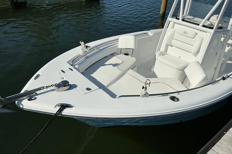 Slide: The Image of 2019 Sea Hunt Ultra 225 boat docked, featuring white seating and sleek design. - 9