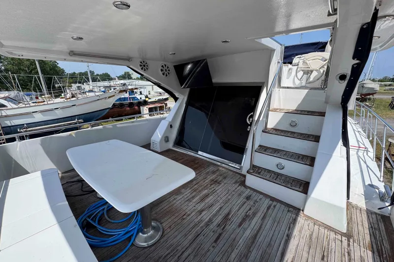 Slide: The Image of Outdoor deck of 2000 Horizon E56 yacht with table, stairs, and marina view. - 28